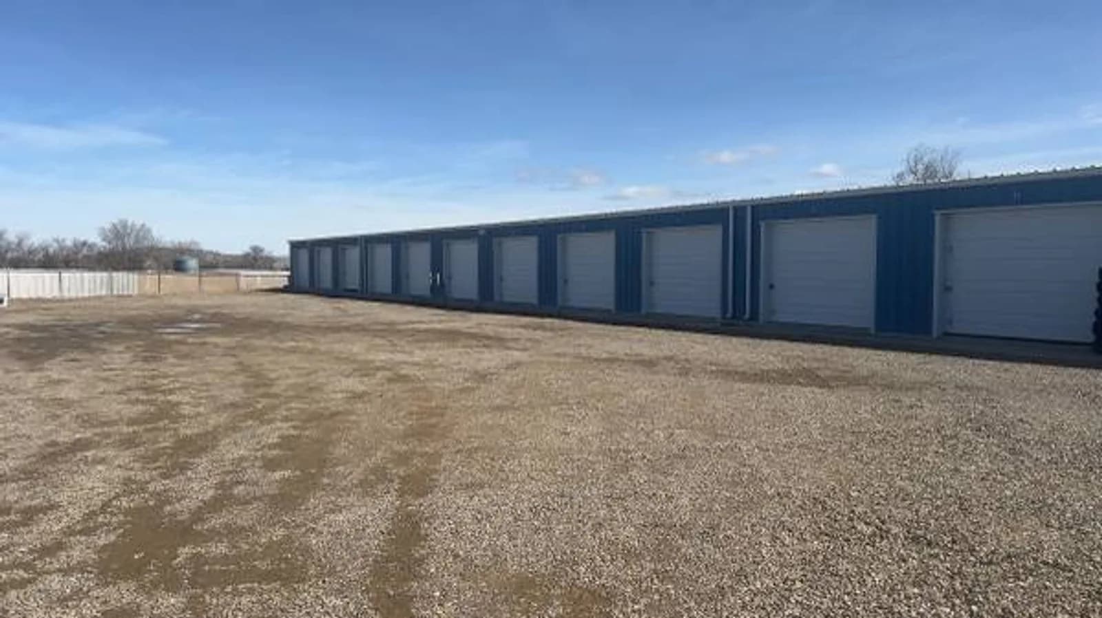 Blue storage-unit doors and gravel access yard in Chino Valley